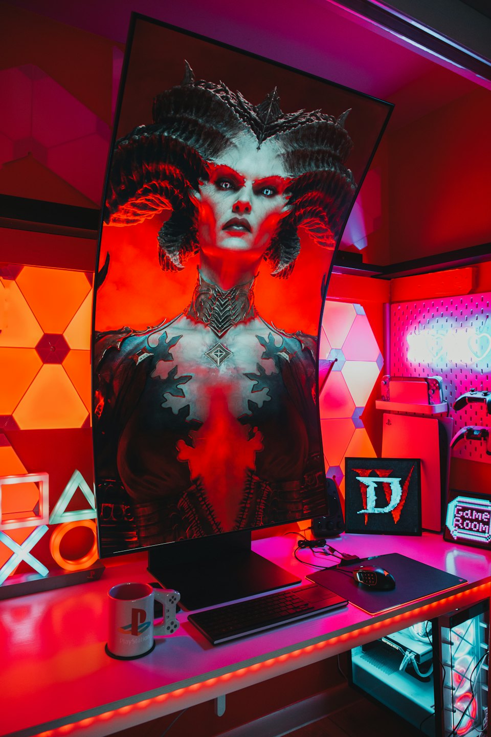 Bureau de jeu avec moniteur incurvé, clavier et symboles PlayStation.