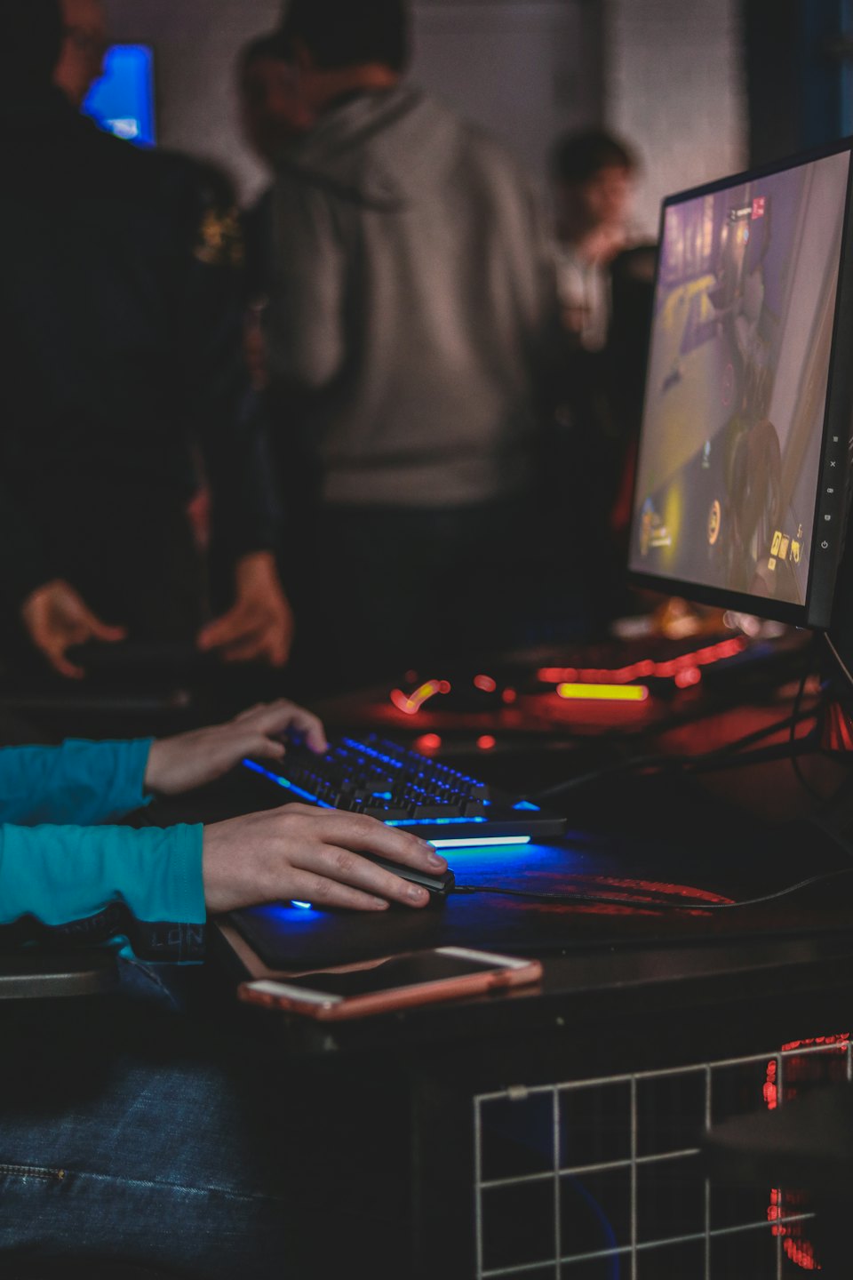 Mains tapant sur un clavier de jeu éclairé et utilisant une souris.
